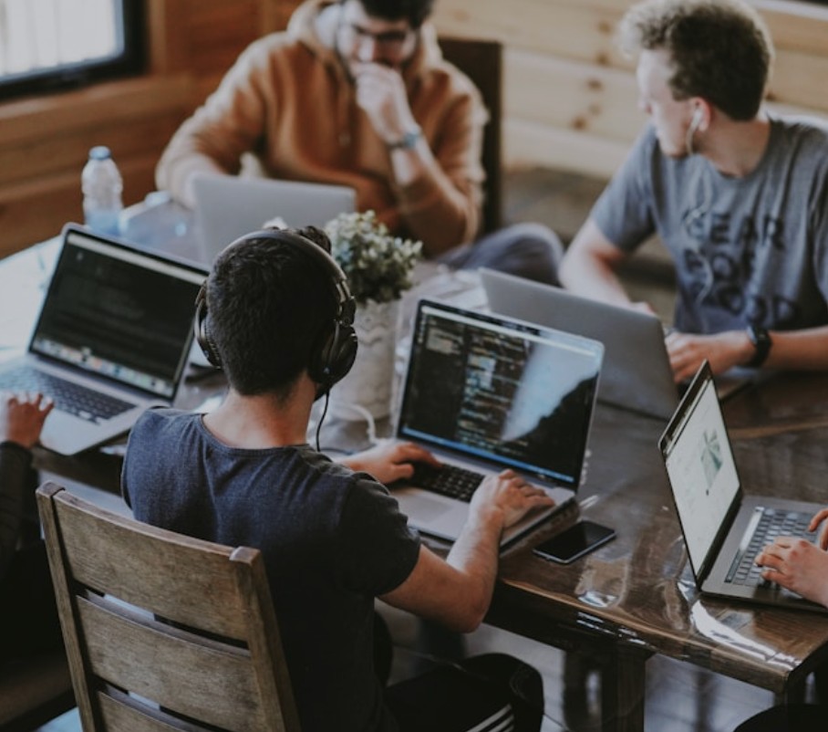 Collaborative team working together on laptops in a modern office